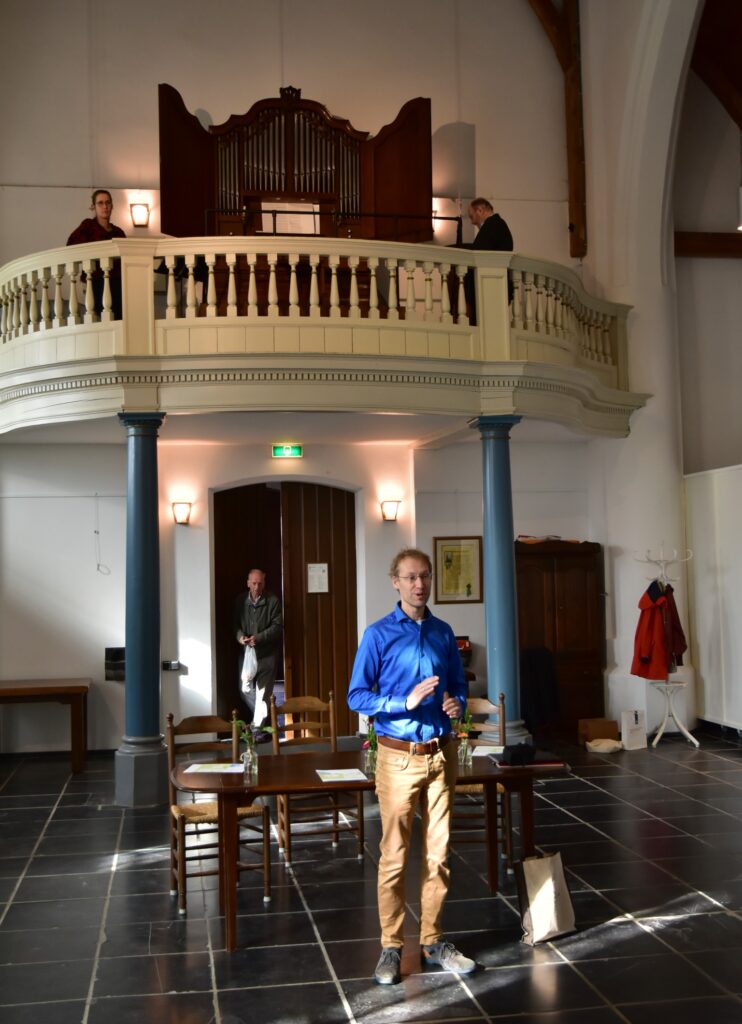 Eelco Kooiker licht het programma toe dat hij met Evelien Wolting (links op het doksaal) in het Oude Kerkje in Middelbeers zal uitvoeren